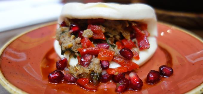 Edges sweet lamb, slow roasted and shredded, inside Hirata buns with mint, pomegranate and Piquilo pepper.”