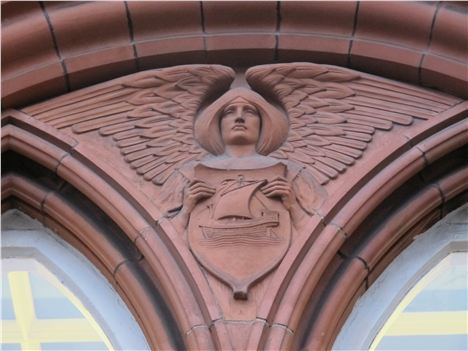 Neatby angel holding a shield with the ship on Manchester's coat of arms