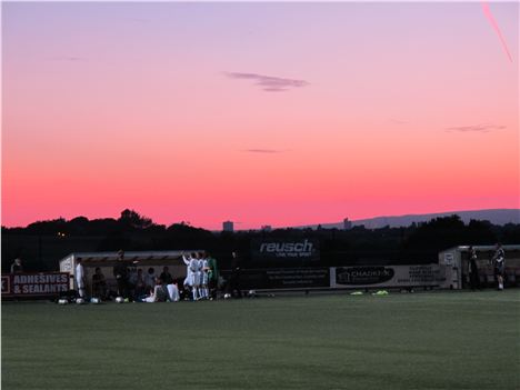 Sunset with footballers looking into the city centre, CIS Tower in the right distance