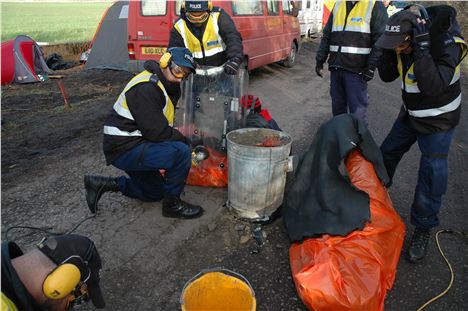 Two protestors attached themselves to a drum filled with concrete, glass and barbed wire